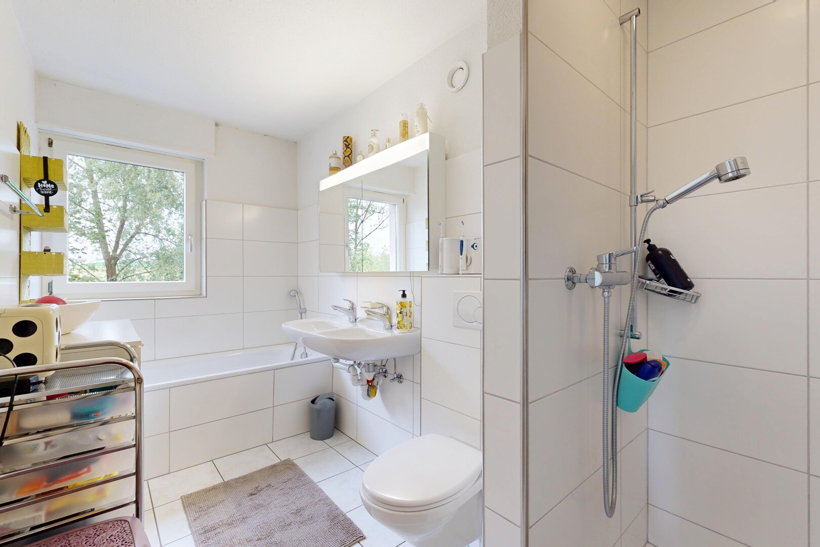 bathroom featuring a garden tub, a walk in shower, healthy amount of natural light, and tile walls
