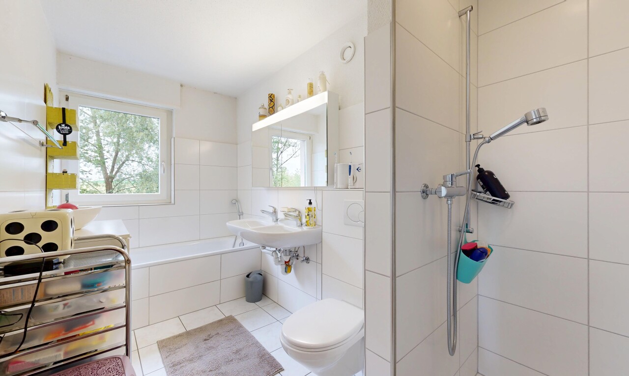 bathroom featuring a garden tub, a walk in shower, healthy amount of natural light, and tile walls