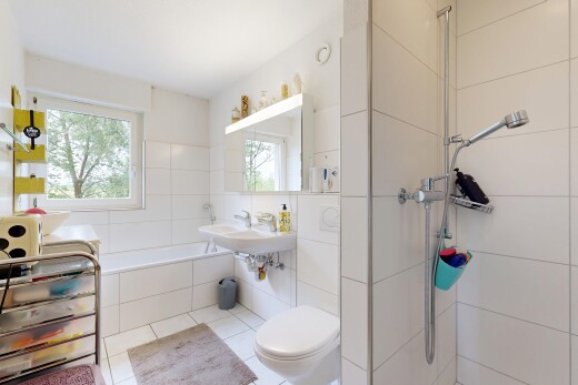 bathroom featuring a garden tub, a walk in shower, healthy amount of natural light, and tile walls