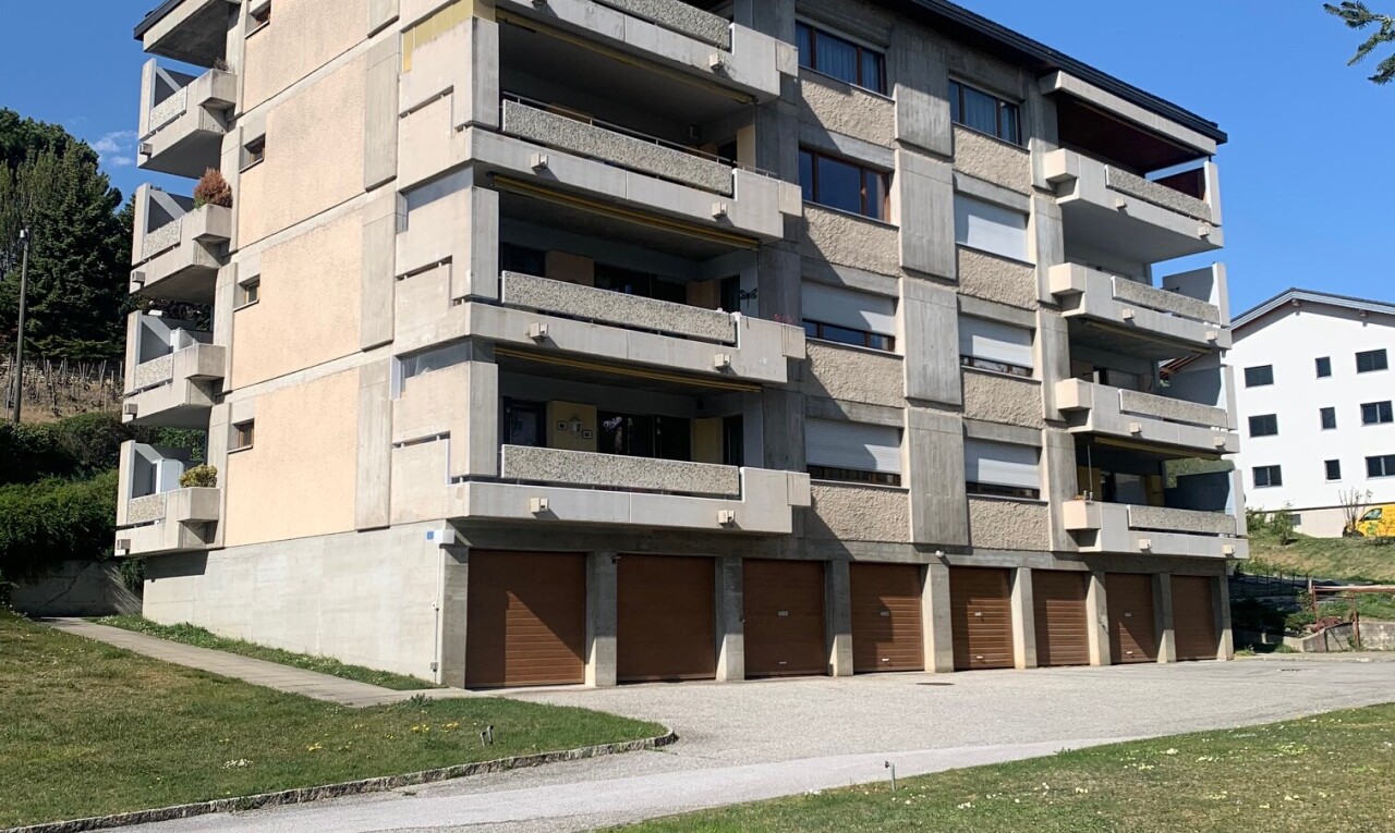 view of apartment building / complex with community garages