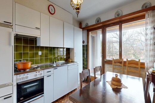 kitchen with wall oven, white cabinetry, built in fridge, and dark countertops