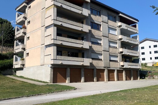 view of apartment building / complex with community garages