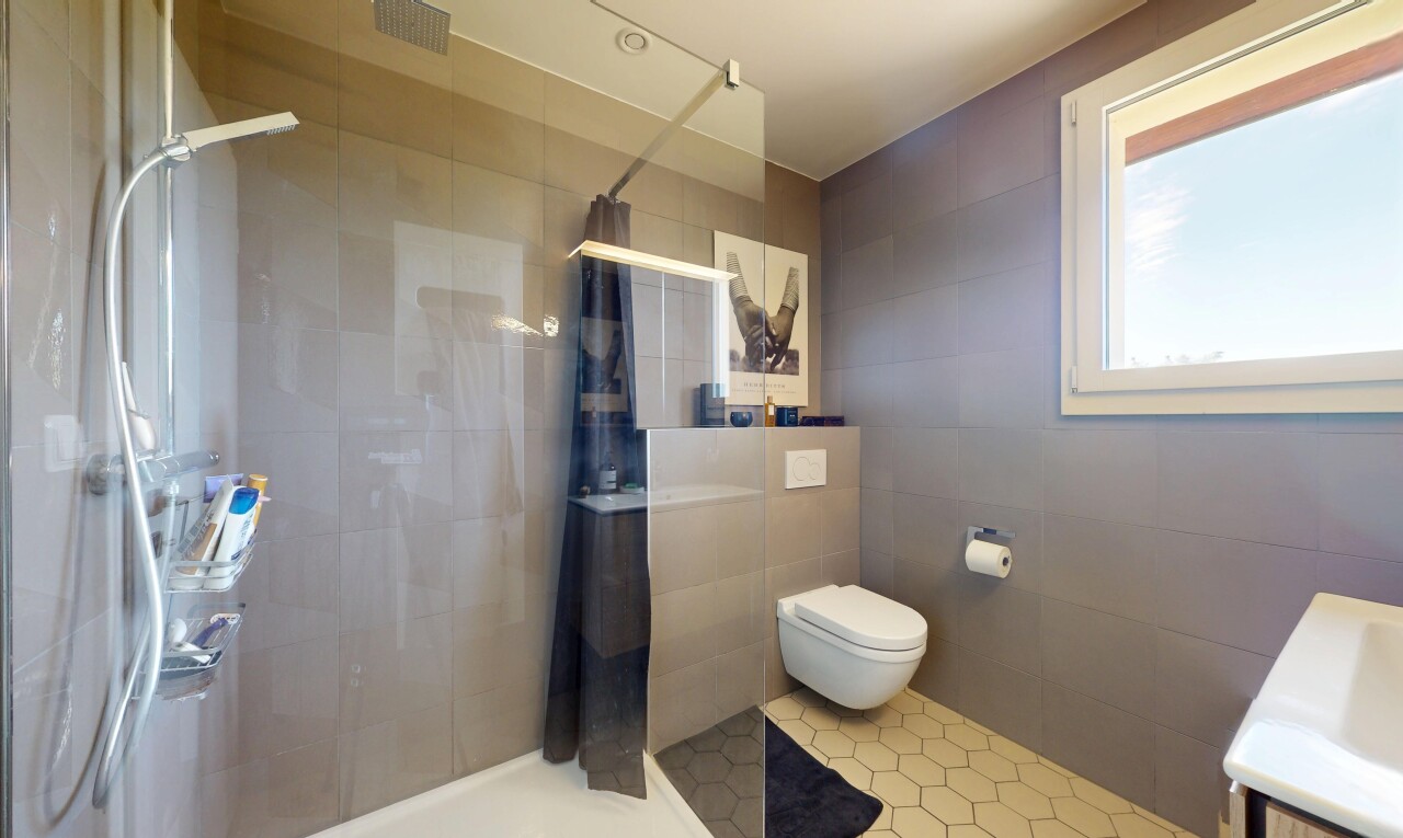 salle de bains avec douche, tile wall, mur en carrelage, inside property, et salle de bain complète