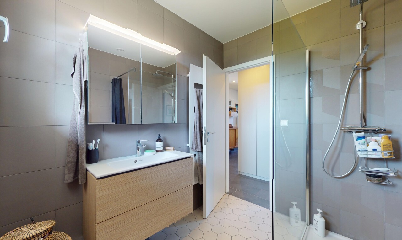 salle de bains avec douche, salle de bain complète, lavabo (ou coiffeuse selon le contexte), miroir, et inside property