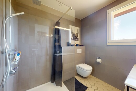 salle de bains avec douche, tile wall, mur en carrelage, inside property, et salle de bain complète