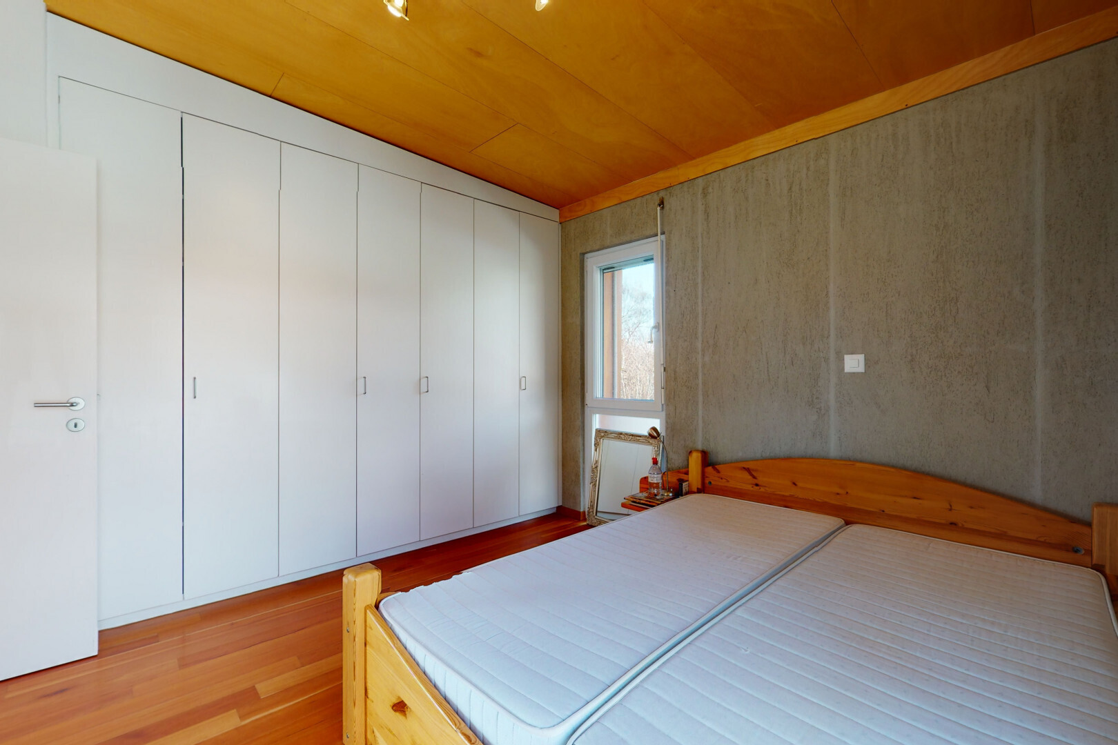 zimmer / schlafzimmer mit inside property, wood finish floor, holzfußboden, natural light, und natürliches licht