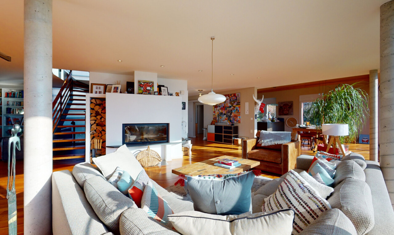 wohnzimmer mit inside property, dekorative säulen, kamin, wood finish floor, und holzfußboden
