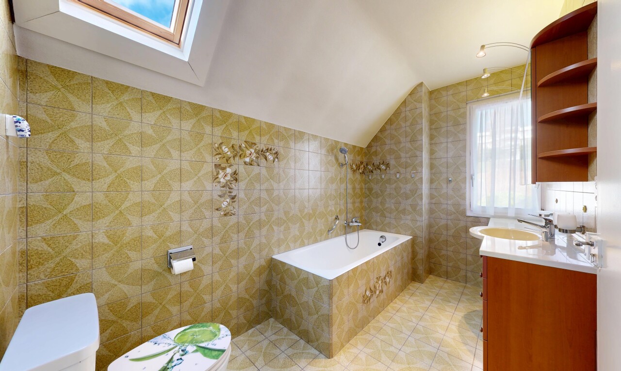 salle de bains avec natural light, lumière naturelle, vaulted ceiling, plafond voûté, et tile wall