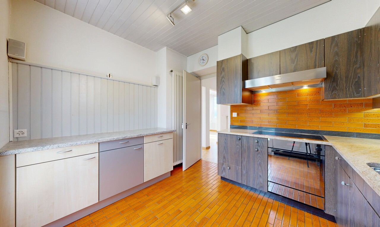 cuisine avec four, light countertops, sol en finition bois, wood finish floor, et light floor