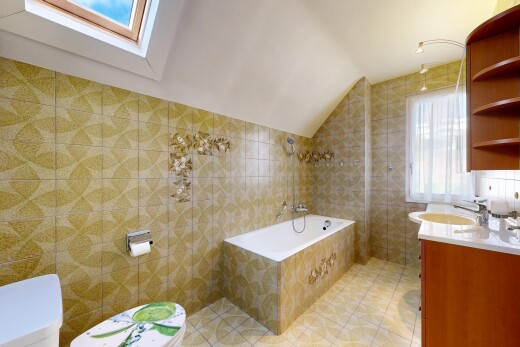 salle de bains avec natural light, lumière naturelle, vaulted ceiling, plafond voûté, et tile wall