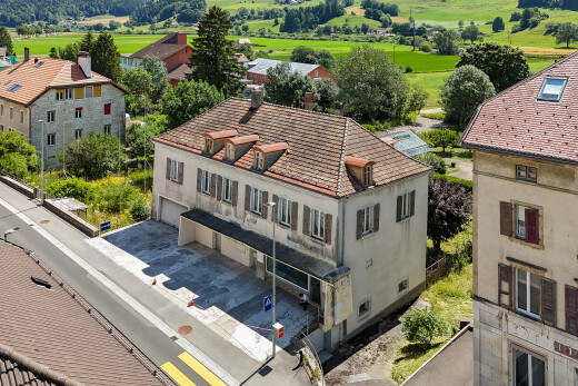 façade avec bardage en stuc, garage intégré, et allée
