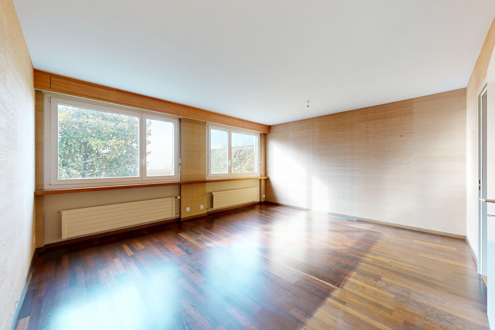leerer raum mit kühler, holzfußboden, wood finish floor, inside property, und natürliches licht