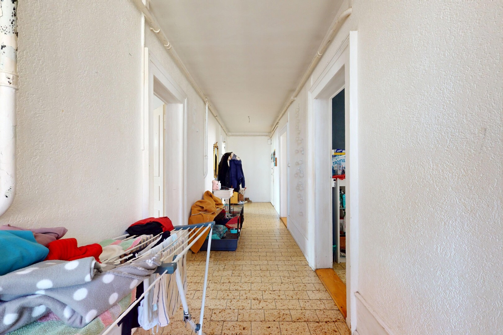 couloir avec mur texturé et sol en vinyle