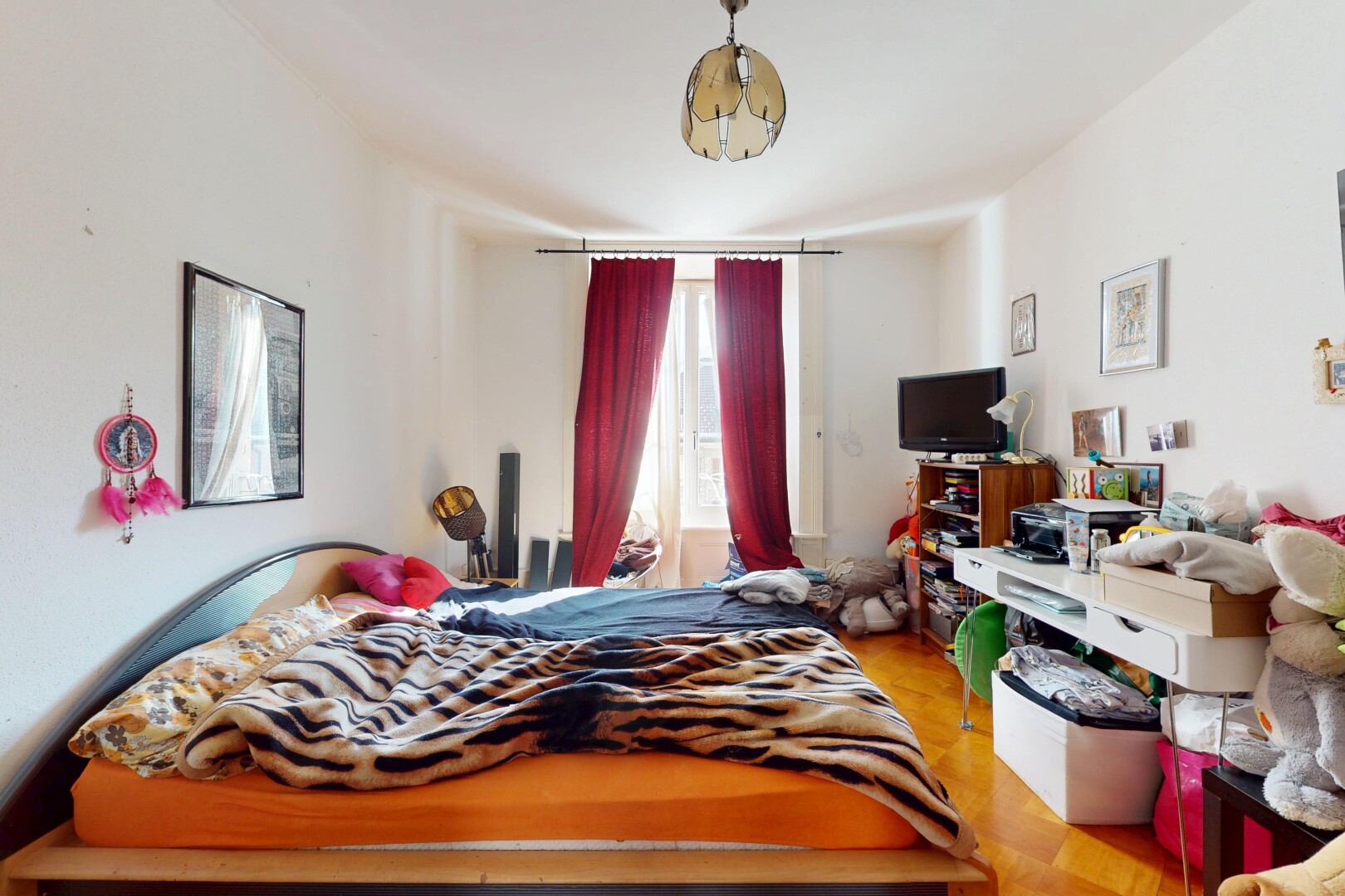 chambre avec lumière naturelle, cloison sèche, sol en finition bois, et télévision