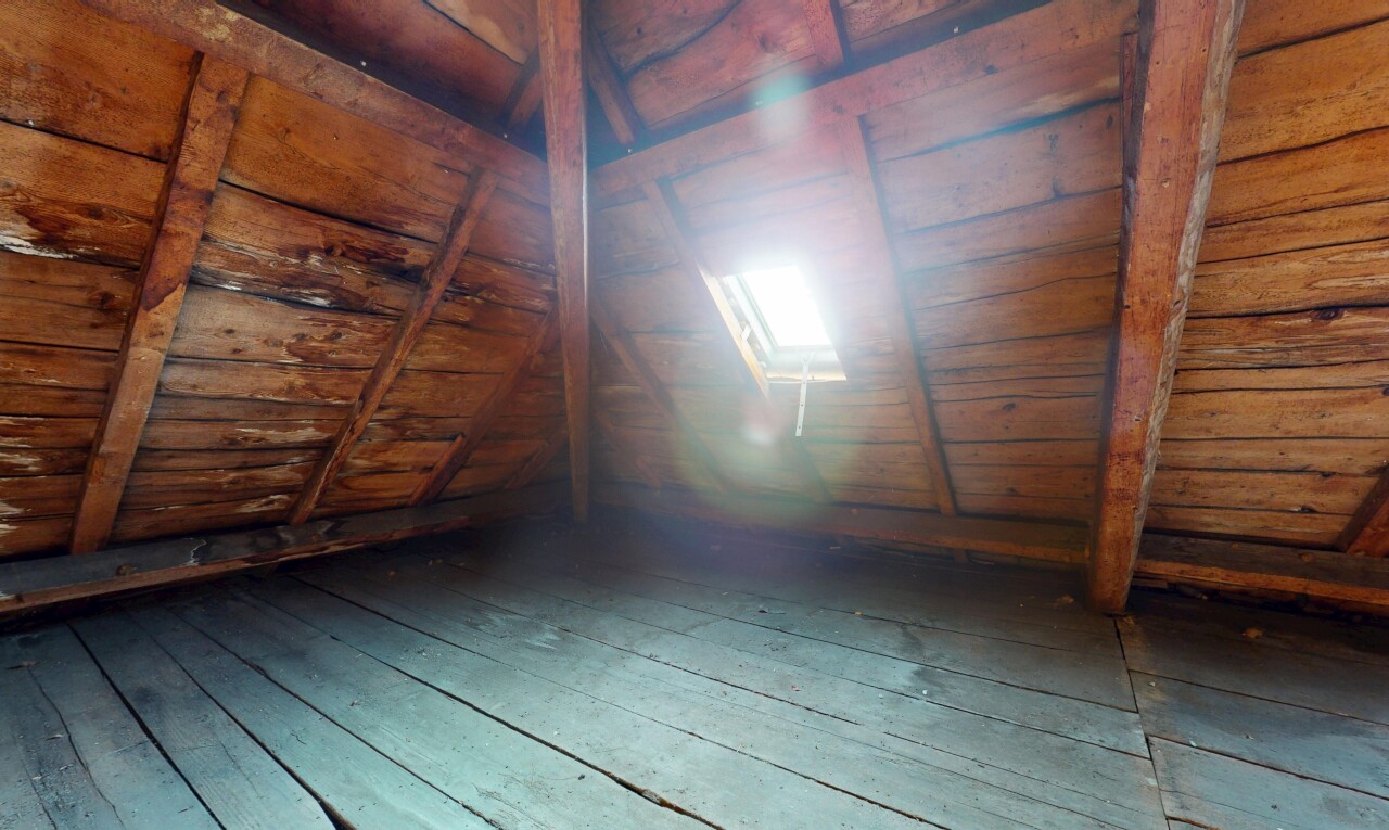 pièce vide avec plafond voûté, sol en finition bois, et plafond bas