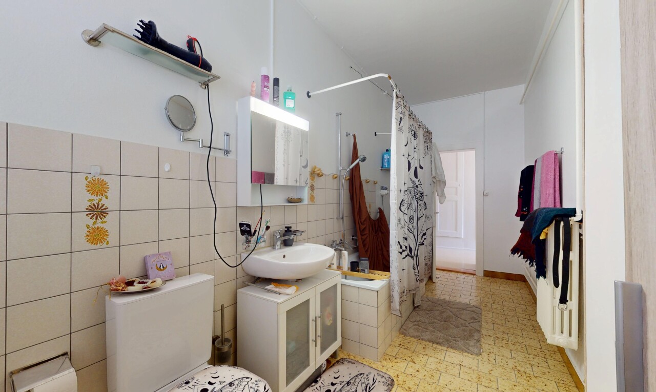 salle de bains avec douche-bain combinés, évier, miroir, salle de bain complète, et sol en vinyle