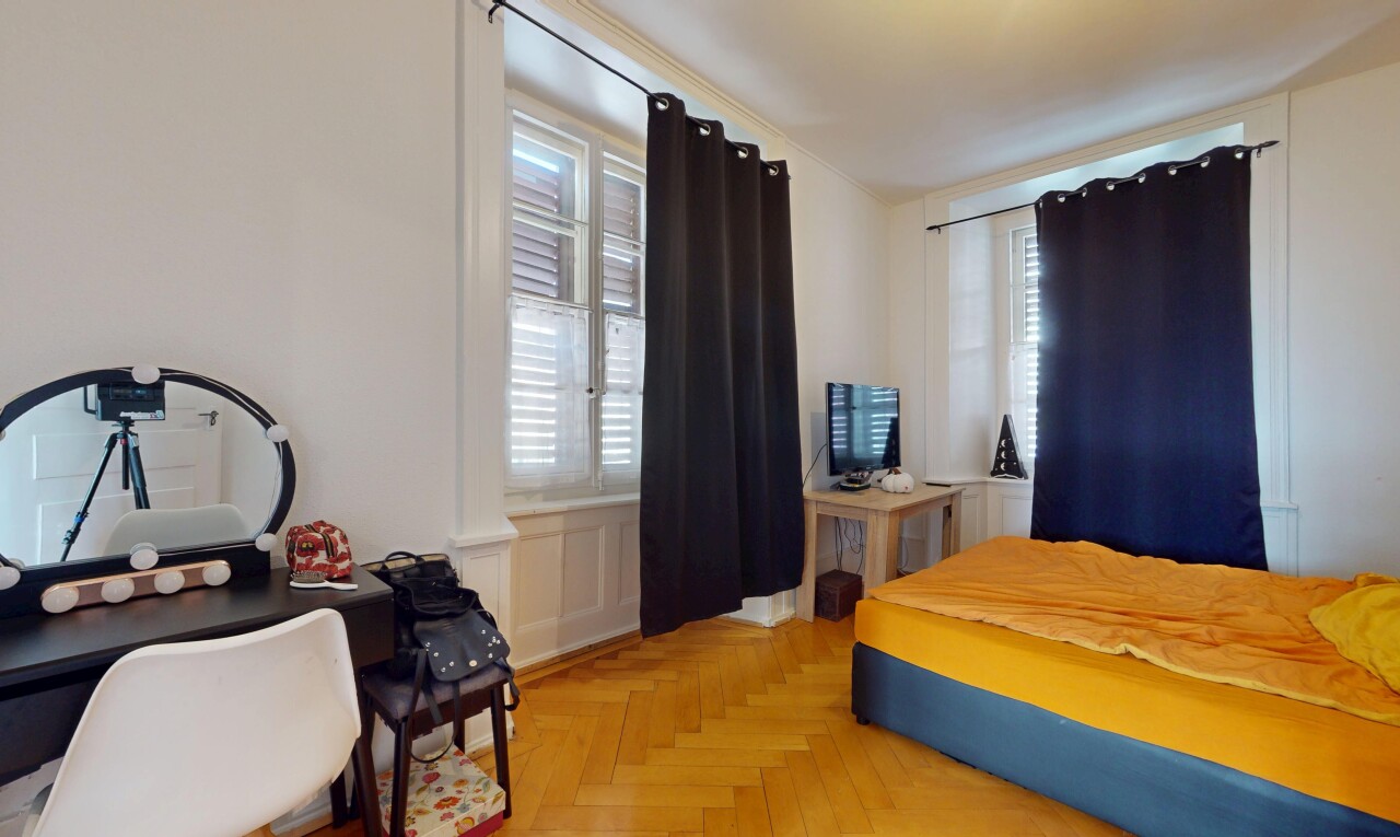chambre avec télévision, lumière naturelle, et cloison sèche