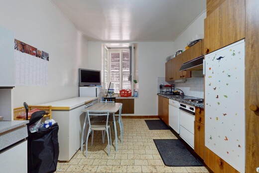 küche mit dunstabzugshaube, gipskartonwand, mittelbraune schränke, fernseher, und vinylboden