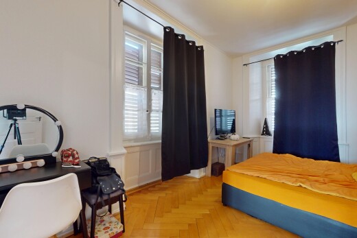chambre avec télévision, lumière naturelle, et cloison sèche