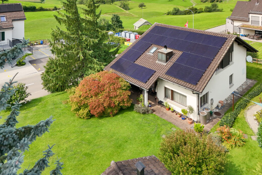 außenansicht mit solaranlage, drone view, stuckverkleidung, und rasen