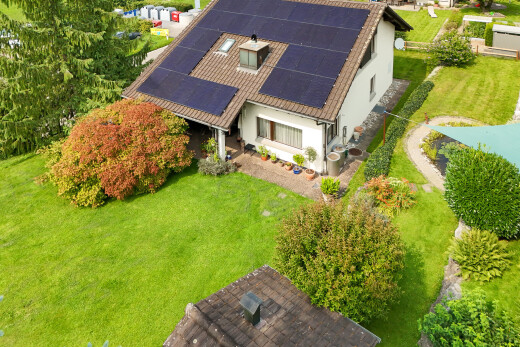 außenansicht mit property visible, stuckverkleidung, solaranlage, und rasen