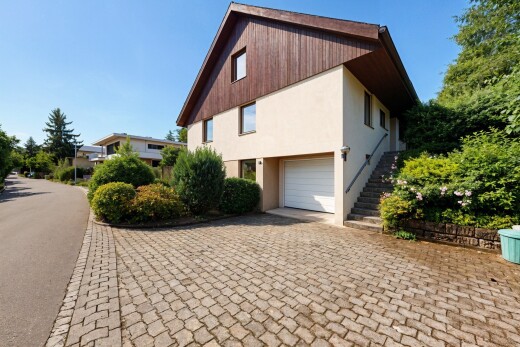 außenansicht mit vertikale verkleidung, eingebaute garage, auffahrt, property visible, und day time