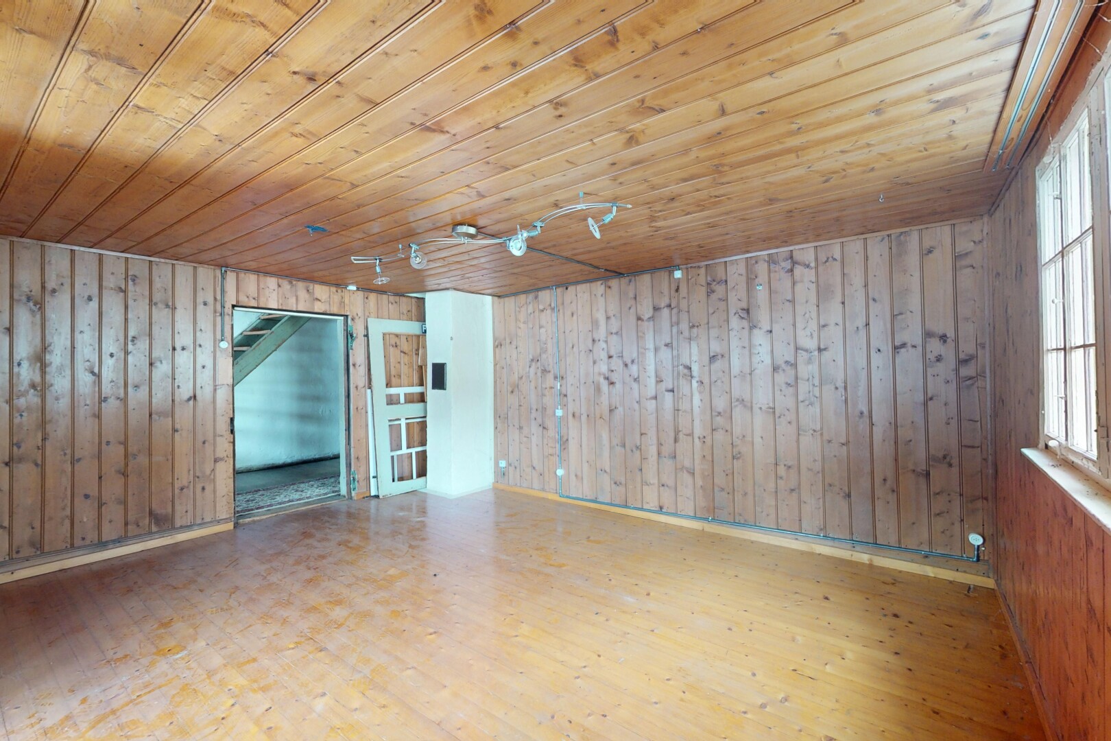pièce vide avec lumière naturelle, mur en bois, plafond en bois, et sol en finition bois