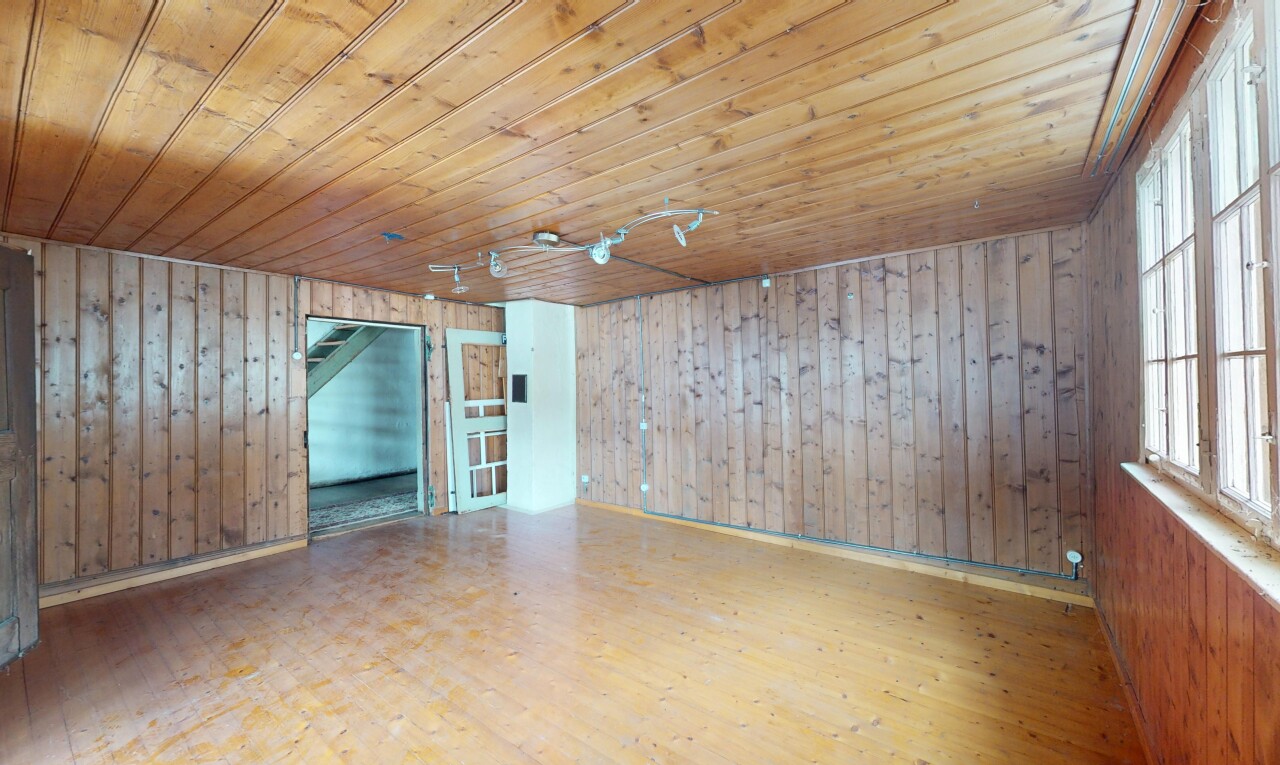 pièce vide avec lumière naturelle, mur en bois, plafond en bois, et sol en finition bois