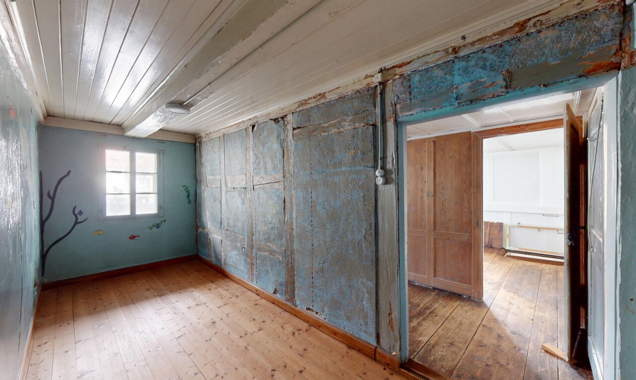 pièce vide avec lumière naturelle, plafond en bois, et sol en finition bois