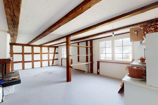 chambre avec lumière naturelle, plafond à poutres, cloison sèche, et cheminée