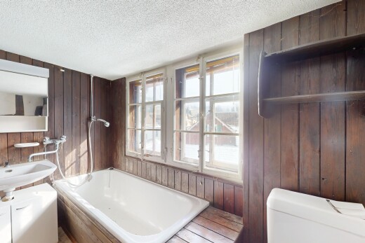 salle de bains avec mur en bois, salle de bain complète, bain, et lumière naturelle