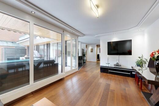 wohnzimmer mit fernseher, gipskartonwand, drywall, holzfußboden, und wood finish floor