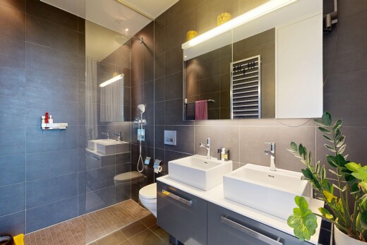salle de bains avec chauffe-serviettes, mur en carrelage, tile wall, double vasque, et douche