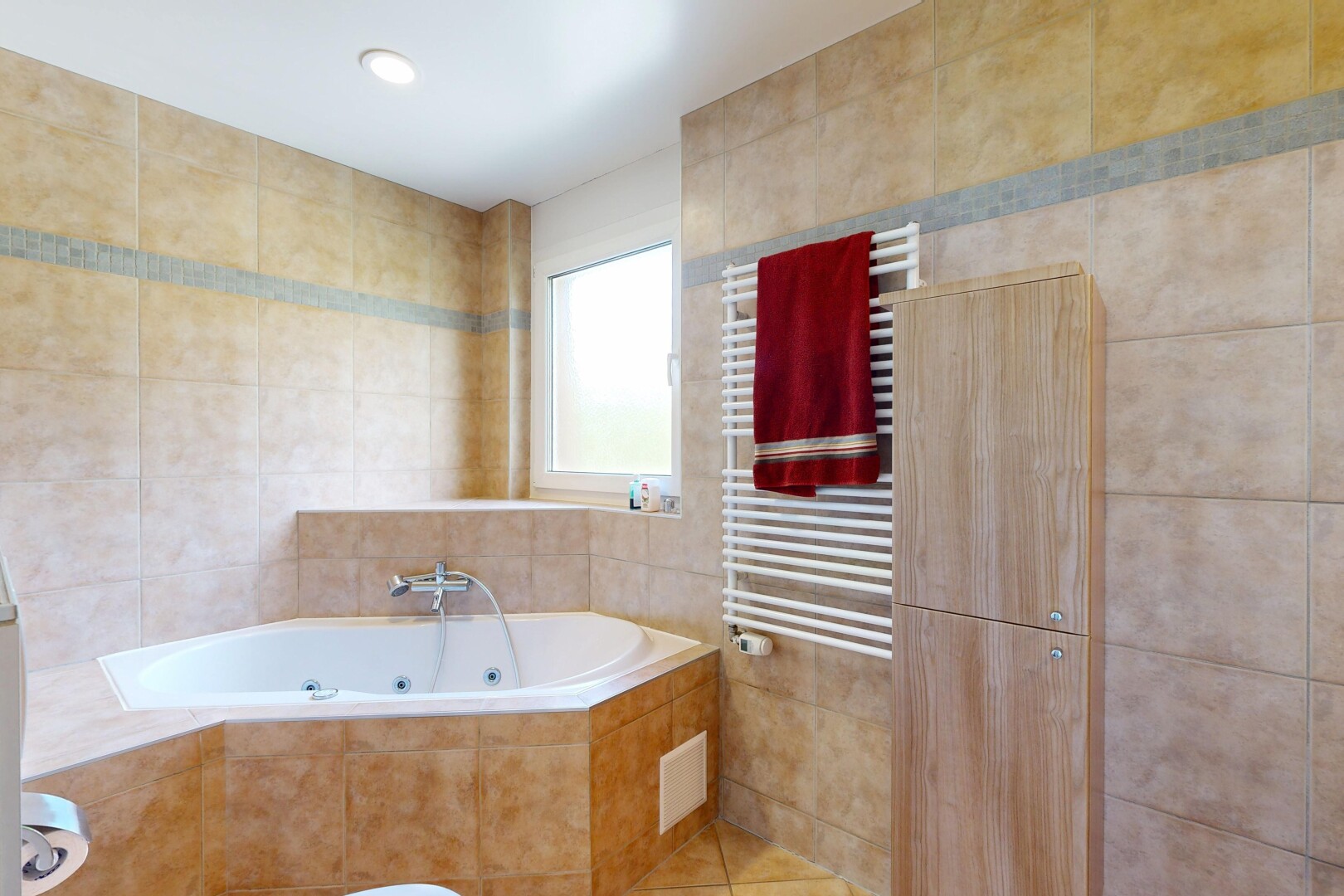 salle de bains avec chauffe-serviettes, tile wall, mur en carrelage, radiateur, et bain