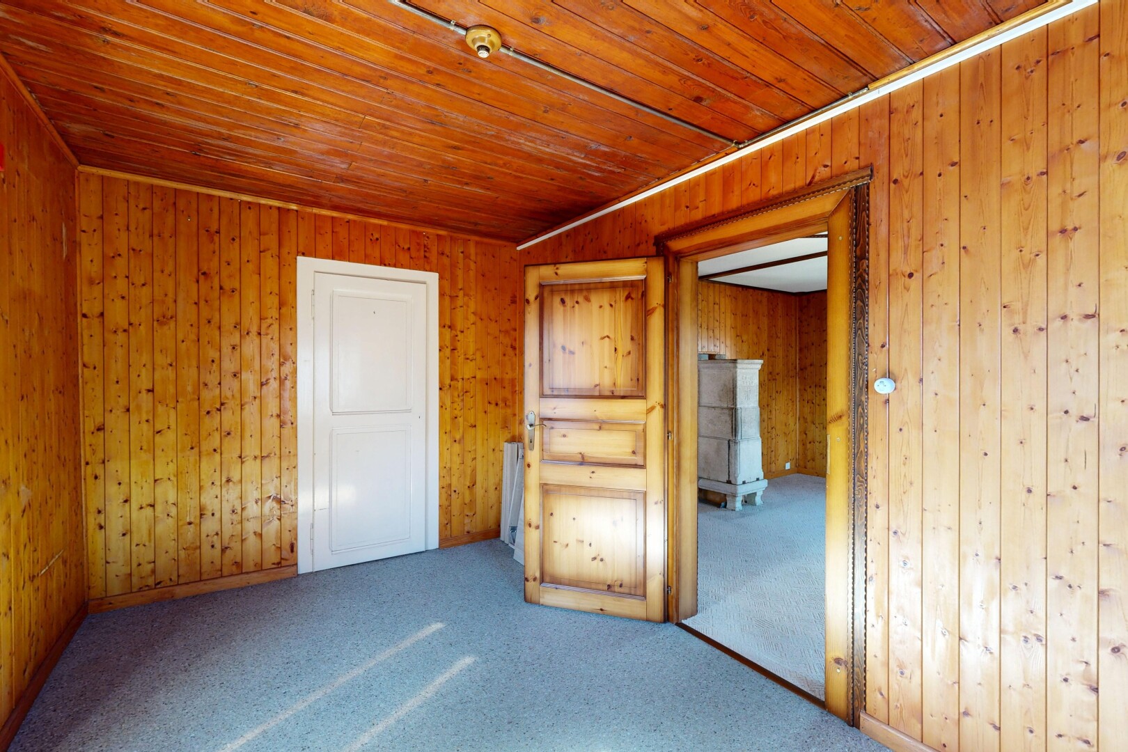 spare room featuring carpet flooring, wood ceiling, and wood walls