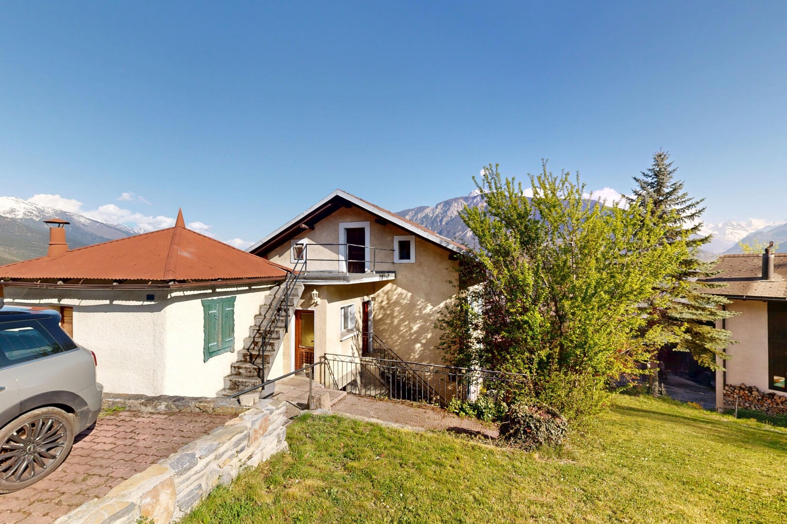 view of property with stucco siding, a lawn, and a balcony
