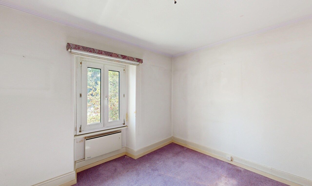 empty room with light carpet and radiator heating unit