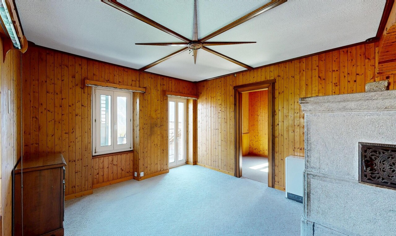 carpeted spare room with a fireplace, a textured ceiling, and wood walls