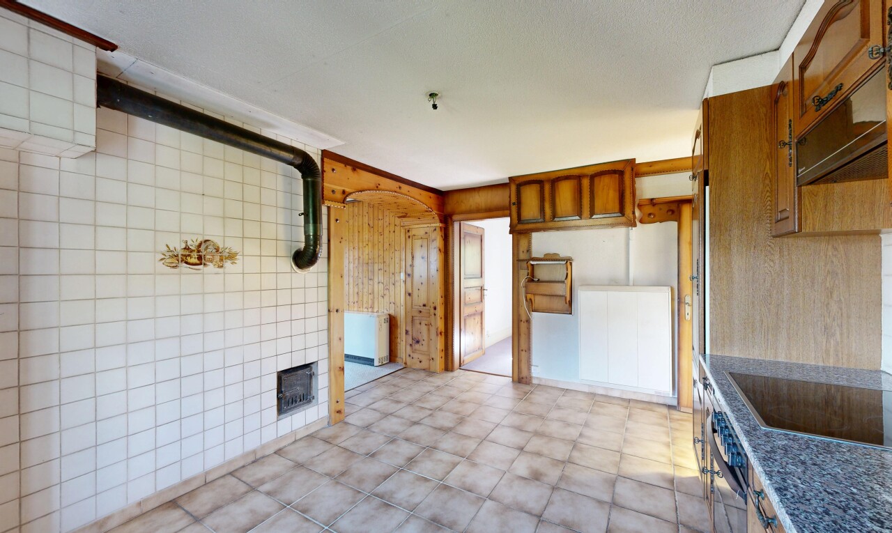 kitchen with stainless steel oven, wood walls, black electric stovetop, dark countertops, and wood finish cabinetry