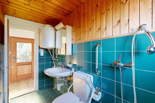 salle de bains avec toilette, chauffe-eau, tile wall, mur en carrelage, et tile floor