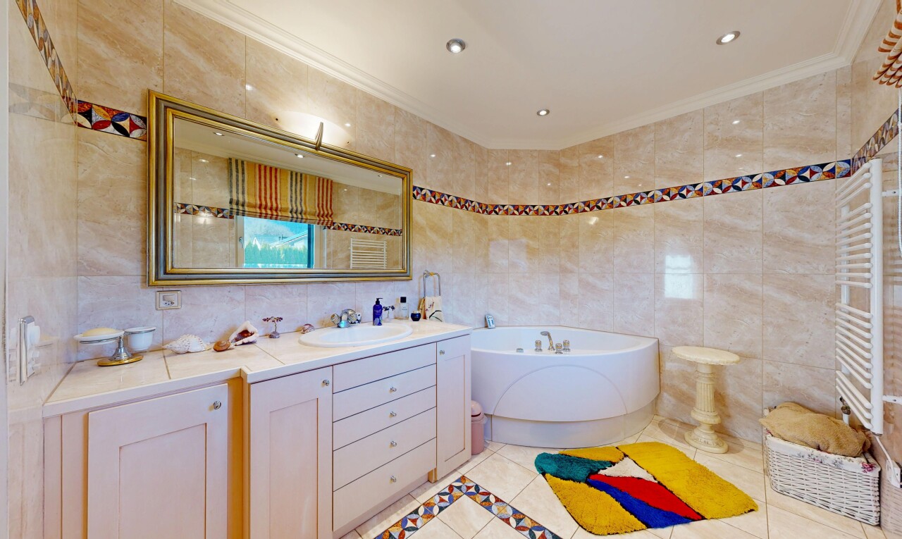 salle de bains avec chauffe-serviettes, mur en carrelage, tile wall, lavabo (ou coiffeuse selon le contexte), et light floor