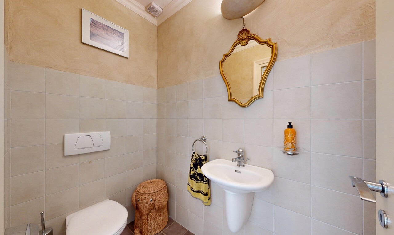 salle de bains avec miroir, tile wall, mur en carrelage, toilette, et inside property