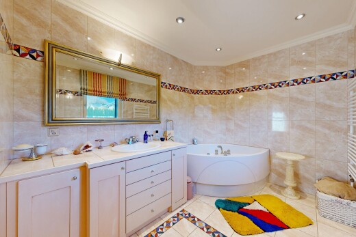 salle de bains avec chauffe-serviettes, mur en carrelage, tile wall, lavabo (ou coiffeuse selon le contexte), et light floor