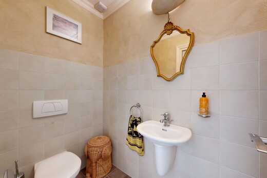 salle de bains avec miroir, tile wall, mur en carrelage, toilette, et inside property