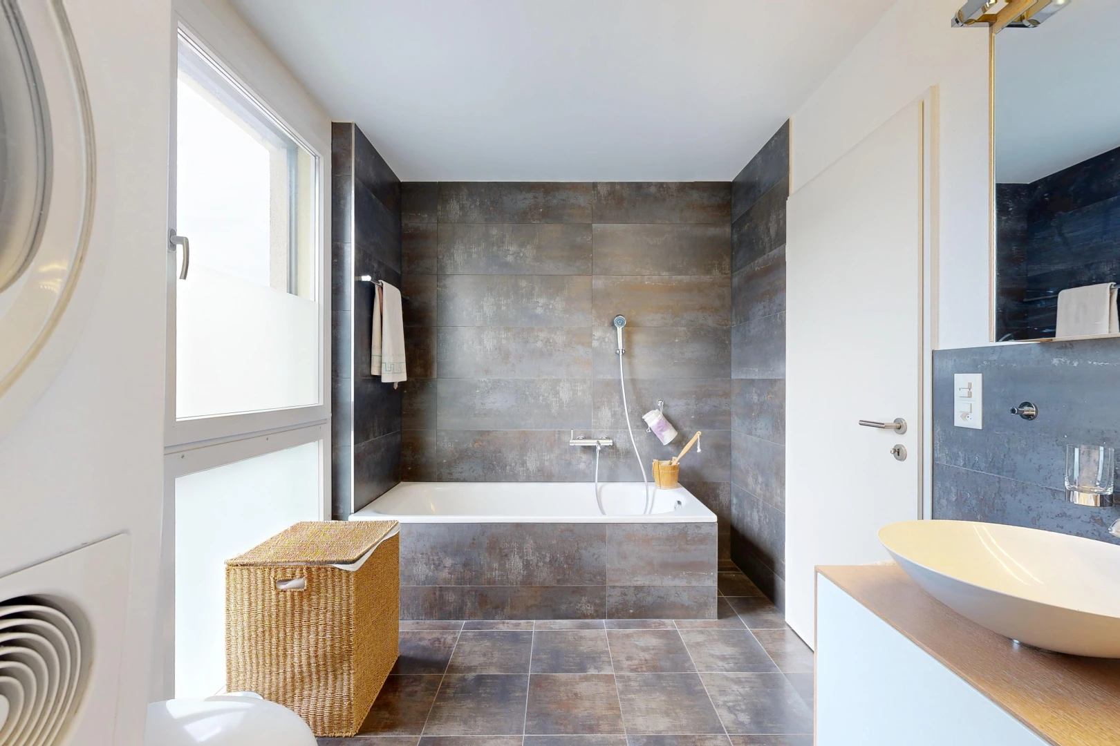 full bath featuring a bath, vanity, and tile walls