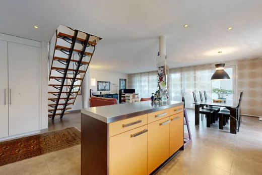 kitchen featuring stainless steel counters, a kitchen island, open floor plan, hanging light fixtures, and modern cabinets