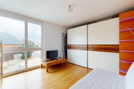 chambre avec télévision, sol en finition bois, wood finish floor, cloison sèche, et drywall