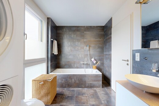 salle de bains avec bain, salle de bain complète, miroir, lavabo (ou coiffeuse selon le contexte), et évier