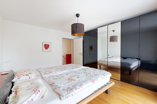 chambre avec cloison sèche, drywall, éclairage suspendu, placard, et sol en finition bois