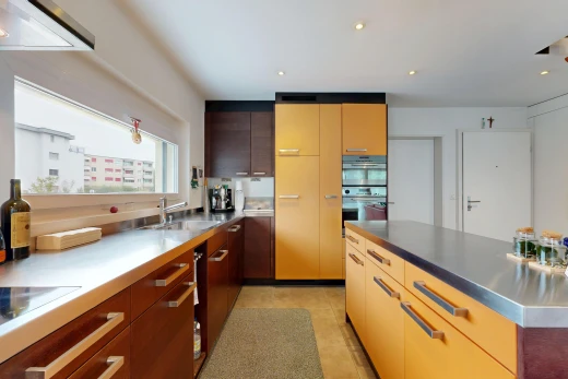 kitchen with stainless steel counters, recessed lighting, modern cabinets, two tone cabinetry, and extractor fan
